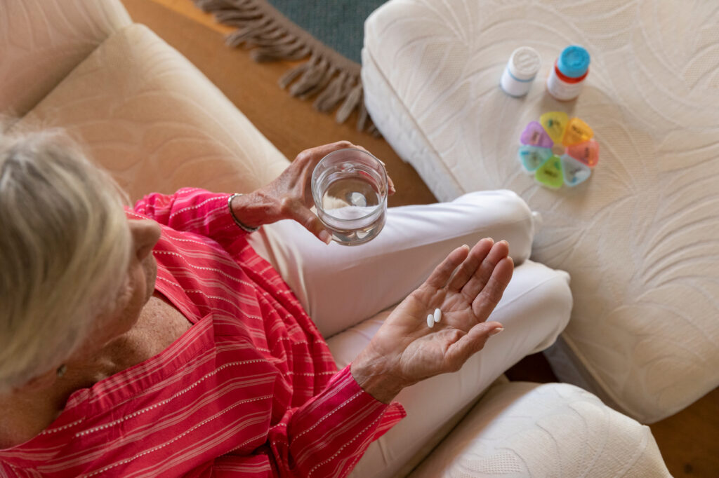 Senior woman organizes prescription pill medication at home