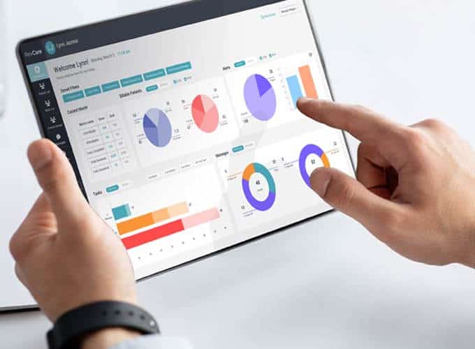 blog-article-image Closeup of a tablet in a Doctors hands with the coachcare dashboard visible on screen