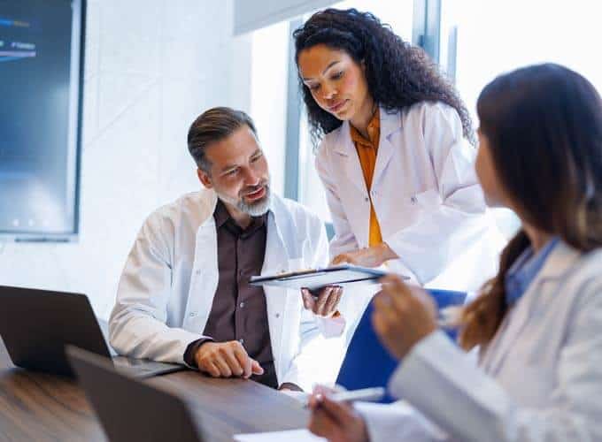 blog-article-image Healthcare professionals discussing medical data and research findings in a modern meeting room