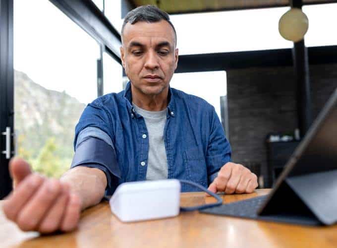 blog-article-image Middle aged Hispanic man checks his Blood Pressure At Home